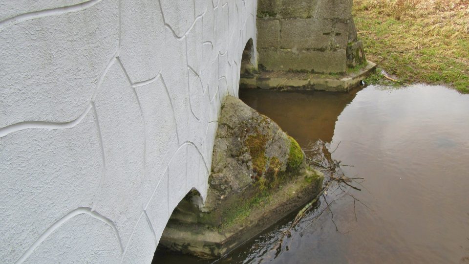 Dno řeky pod mostem je vydlážděné