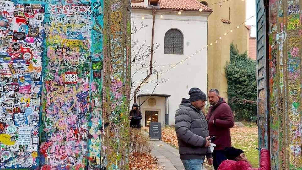 Branka v Lennonově zdi, v pozadí kostel Panny Marie pod řetězem