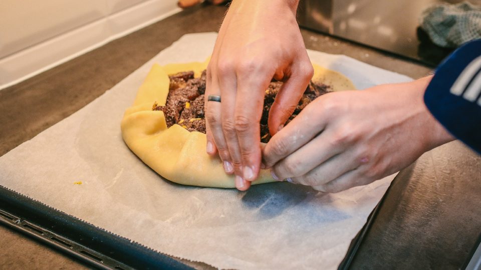 Okraje těsty takzvaně zahrneme přes švestkovou náplň | foto: Jana Volková Okraje těsty takzvaně zahrneme přes švestkovou náplň