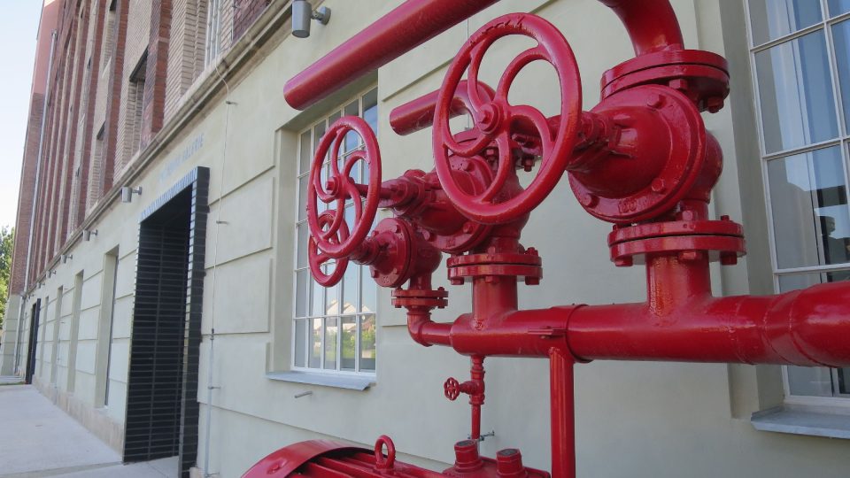 Industriální charakter Automatických mlýnů připomíná u vstupu do Gočárovy galerie historický elektromotor a vodní čerpadlo