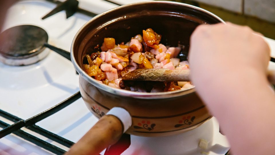 Do rendlíku vložíme špek a slaninu, rozpálíme, přidáme hrst škvarků, nadrobno nakrájenou cibuli a orestujeme